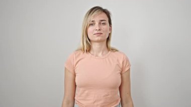 Sarışın genç bir kadın, izole edilmiş beyaz arka planda parmaklarıyla kötü jest yapıyor.