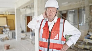 Kıdemli gri saçlı mimar inşaat alanında strese girdi.