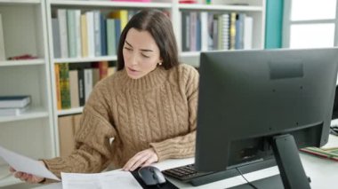 Üniversite sınıfında bilgisayar kırma kağıdı kullanan güzel İspanyol bir kız öğrenci.