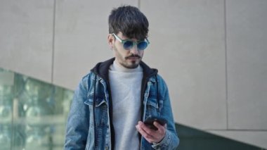 Genç İspanyol adam gülümsüyor. Kendine güveni tam. Akıllı telefonuyla özçekim yapıyor.