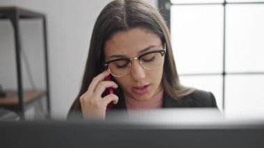 Genç, güzel İspanyol iş kadını akıllı telefondan konuşuyor. Ofiste stresli.