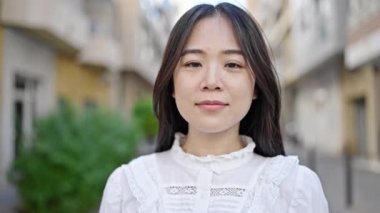 Young chinese woman smiling confident standing at street