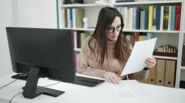 Güzel İspanyol öğrenci kütüphanede kağıt fırlatıyor.