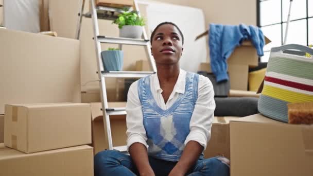 非洲裔美国妇女坐在地板上 在新家用优胜的表情表达自己 — 图库视频影像