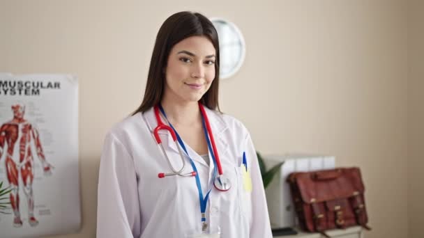 Joven Hermosa Mujer Hispana Médico Sonriendo Confiado Pie Clínica — Vídeo de stock