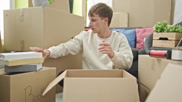 Young Caucasian Man Packing Cardboard Box New Home — Stockvideo