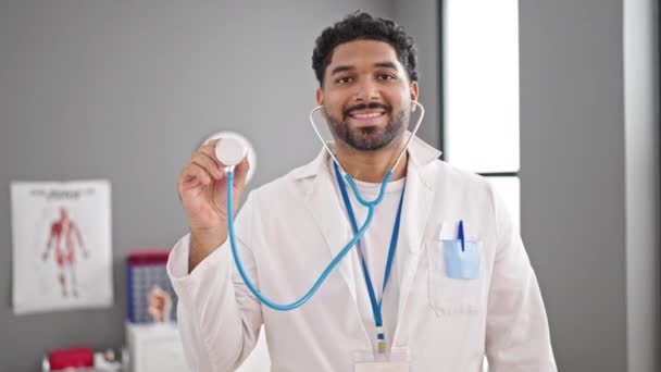 Hombre Afroamericano Doctor Sonriendo Confiado Sosteniendo Estetoscopio Clínica — Vídeos de Stock