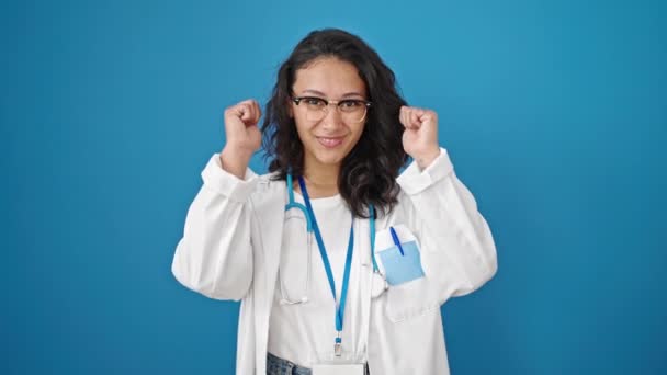 年轻美丽的惊慌失措的女医生用大拇指翻过孤立的蓝色墙壁背景 — 图库视频影像