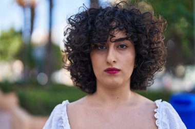 Park yerinde duran rahat yüzlü genç ortadoğulu kadın.