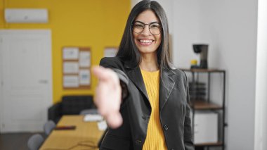 Genç, güzel İspanyol iş kadını gülümseyen, kendine güvenen, ofiste tokalaşan.