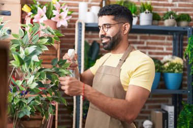 Young arab man florist using difusser working at florist