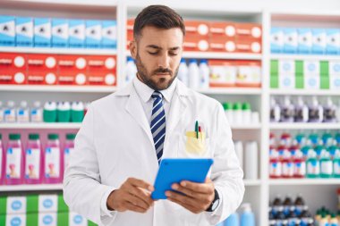 Genç İspanyol eczacı eczanede dokunmatik ped kullanıyor.