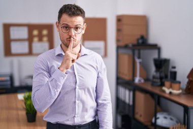 Ofisteki genç İspanyol adam parmakları dudaklarında sessiz olmak istiyor. sessizlik ve gizli konsept. 