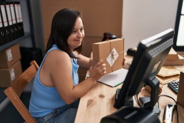 Down sendromlu kadın ecommerce işçisi ofiste paket siparişi gösteren bir video mesajı alıyor.