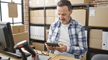 Orta yaşlı bir iş adamı ofiste çalışan touchpad kullanıyor.