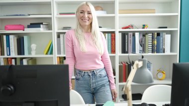 Young blonde woman student smiling confident standing at library university