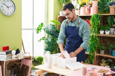 Çiçekçide saksıları açan İspanyol bir çiçekçi.