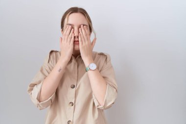 Gündelik tişört giyen, yorgun ve baş ağrısı için gözlerini ovuşturan, uykulu ve yorgun bir ifade takınan beyaz bir kadın. görme sorunu 