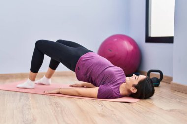 Spor merkezinde kendine güveni tam bir egzersiz yapan genç bir kadın.