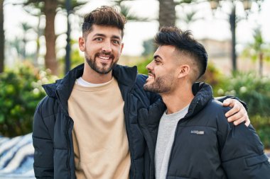 Young couple smiling confident hugging each other at park