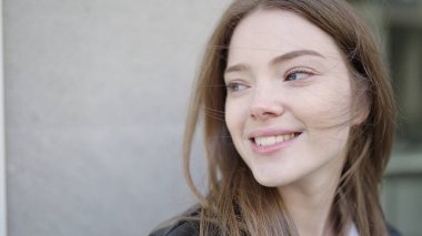Young blonde woman smiling confident looking to the side at street