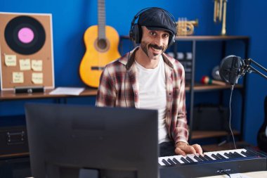 Genç İspanyol müzisyen müzik stüdyosunda piyano çalıyor.