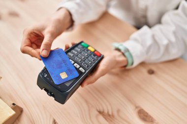 Young caucasian woman using credit card and data phone at office