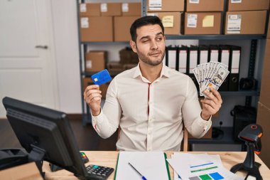 Sakallı genç İspanyol bir adam küçük bir şirkette çalışıyor elinde banknotlar ve kredi kartlarıyla gülümsüyor ve şöyle düşünüyor:. 