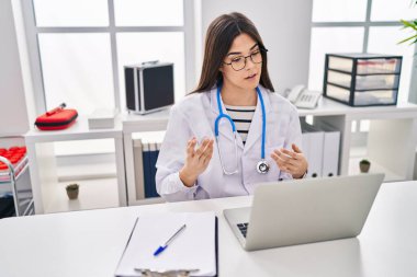 Laptop kullanan güzel İspanyol kadın klinikte video görüşmesi yapıyor.