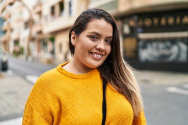 Young beautiful plus size woman smiling confident standing at street