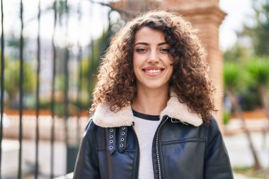 Sokakta kendine gülen genç İspanyol kadın.