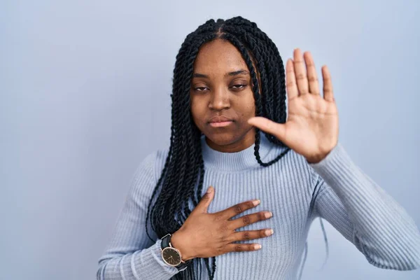 Afrykańska Amerykanka Stojąca Nad Niebieskim Tłem Przysięgająca Ręką Piersi Otwartą — Zdjęcie stockowe