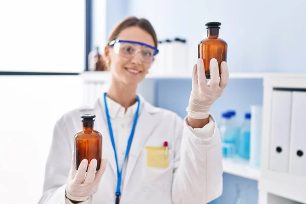 Young Caucasian Woman Scientist Holding Bottles Laboratory — Stockfoto