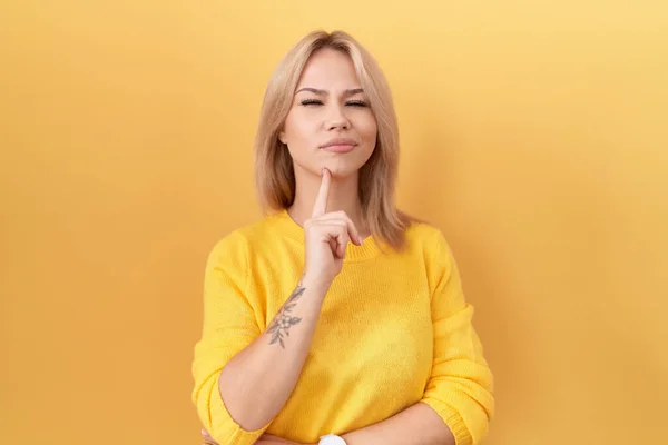 Young Caucasian Woman Wearing Yellow Sweater Thinking Concentrated Doubt Finger — Stock Photo, Image