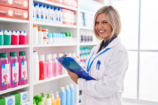 Young Blonde Woman Pharmacist Writing Document Pharmacy — Foto Stock
