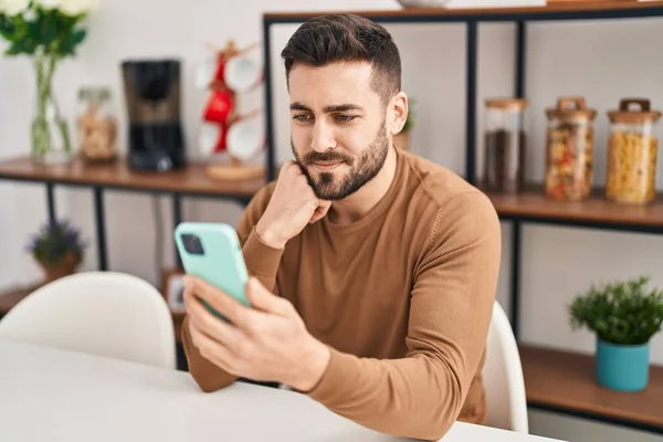 Jonge Spaanse Man Met Smartphone Zittend Tafel Thuis — Stockfoto