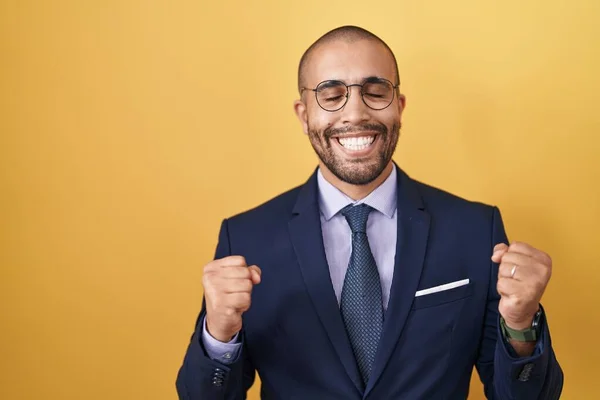 髭を生やしたヒスパニック系の男性がスーツを着て 腕を上げて成功のために興奮ネクタイと目は笑顔勝利を祝う閉じました 勝者のコンセプト — ストック写真
