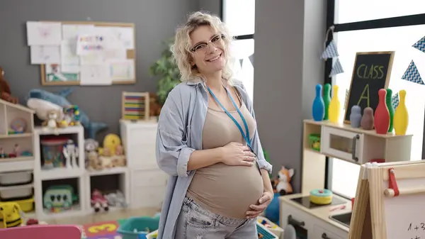 Jonge Zwangere Vrouw Kleuterleidster Glimlachen Zelfverzekerd Aanraken Buik Kleuterschool — Stockfoto