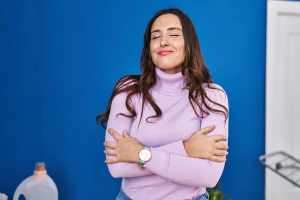 Young Hispanic Woman Smiling Confident Hugging Himself Laundry Room — ストック写真