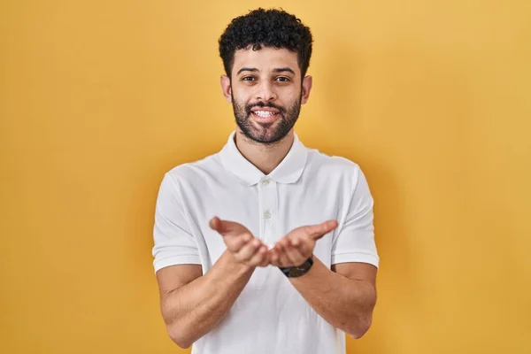 Arabische Man Die Gele Achtergrond Staat Glimlachen Met Handpalmen Bij — Stockfoto