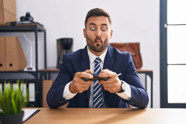 英俊的他的惊慌失措的男人在办公室里玩电子游戏 用嘴和眼神做鬼脸 疯狂而滑稽 — 图库照片