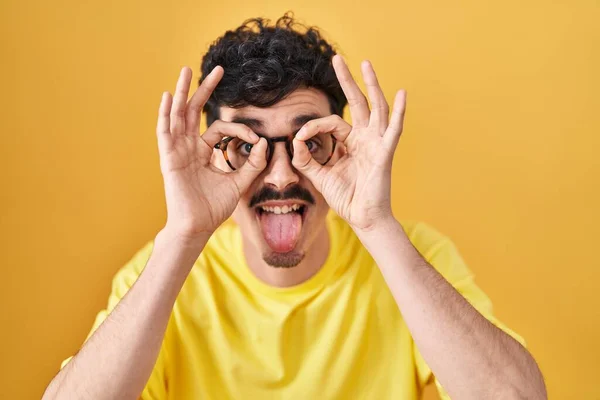 Homem Hispânico Usando Óculos Sobre Fundo Amarelo Fazendo Gesto Como — Fotografia de Stock
