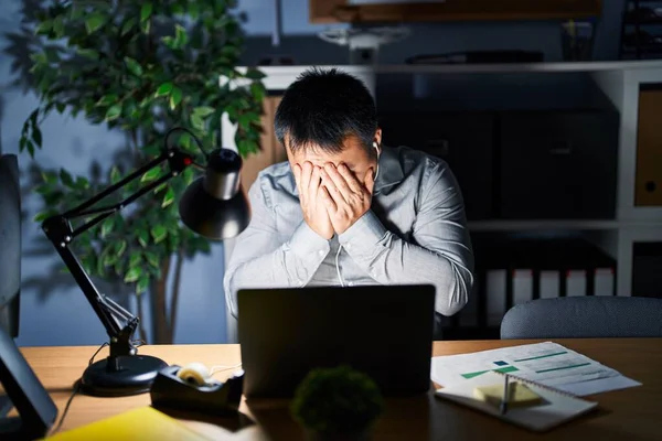 泣きながら手で顔を覆う悲しい表情で夜にコンピュータノートパソコンを使って働く若い中国人男性 うつ病の概念 — ストック写真