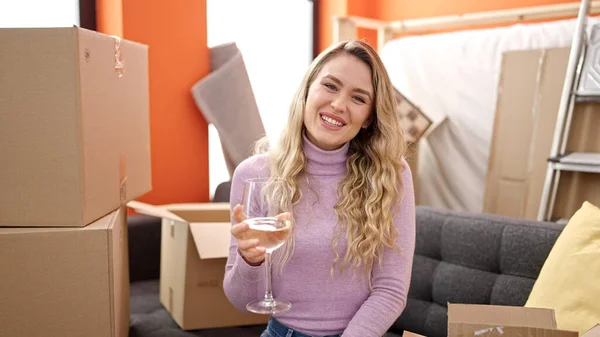 Genç Sarışın Kadın Yeni Evindeki Kanepede Oturmuş Şarap Içiyor — Stok fotoğraf