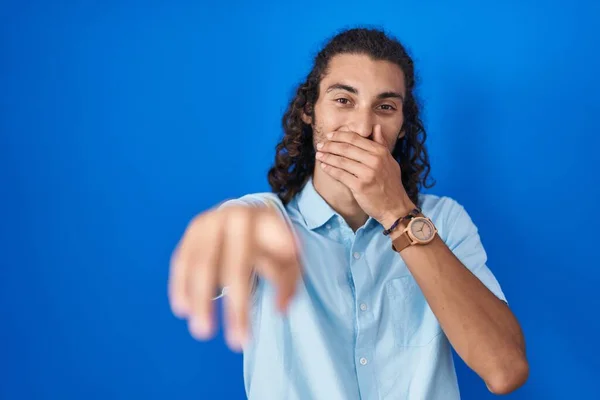 Mladý Hispánec Stojí Nad Modrým Pozadím Směje Ukazuje Prstem Kameru — Stock fotografie
