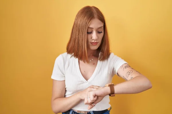 Mujer Pelirroja Joven Pie Sobre Fondo Amarillo Comprobar Hora Reloj —  Fotos de Stock