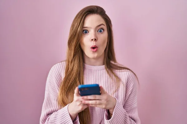 Young Caucasian Woman Using Smartphone Typing Message Afraid Shocked Surprise — Stock Photo, Image