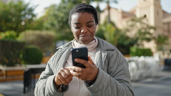 Αφροαμερικανή Γυναίκα Που Χρησιμοποιεί Smartphone Χαμογελώντας Στο Πάρκο — Φωτογραφία Αρχείου