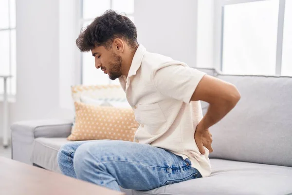 Young Arab Man Suffering Backache Sitting Sofa Home — Stockfoto