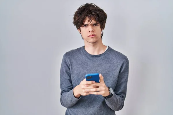 Giovane Utilizzando Smartphone Digitando Messaggio Scettico Nervoso Accigliato Sconvolto Causa — Foto Stock